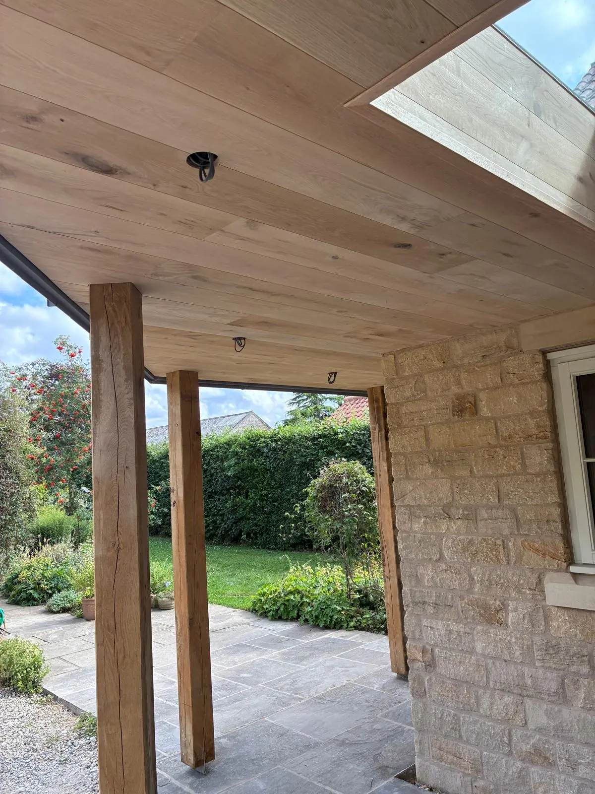 Oak posts and oak-lined soffit framing the view of the garden
