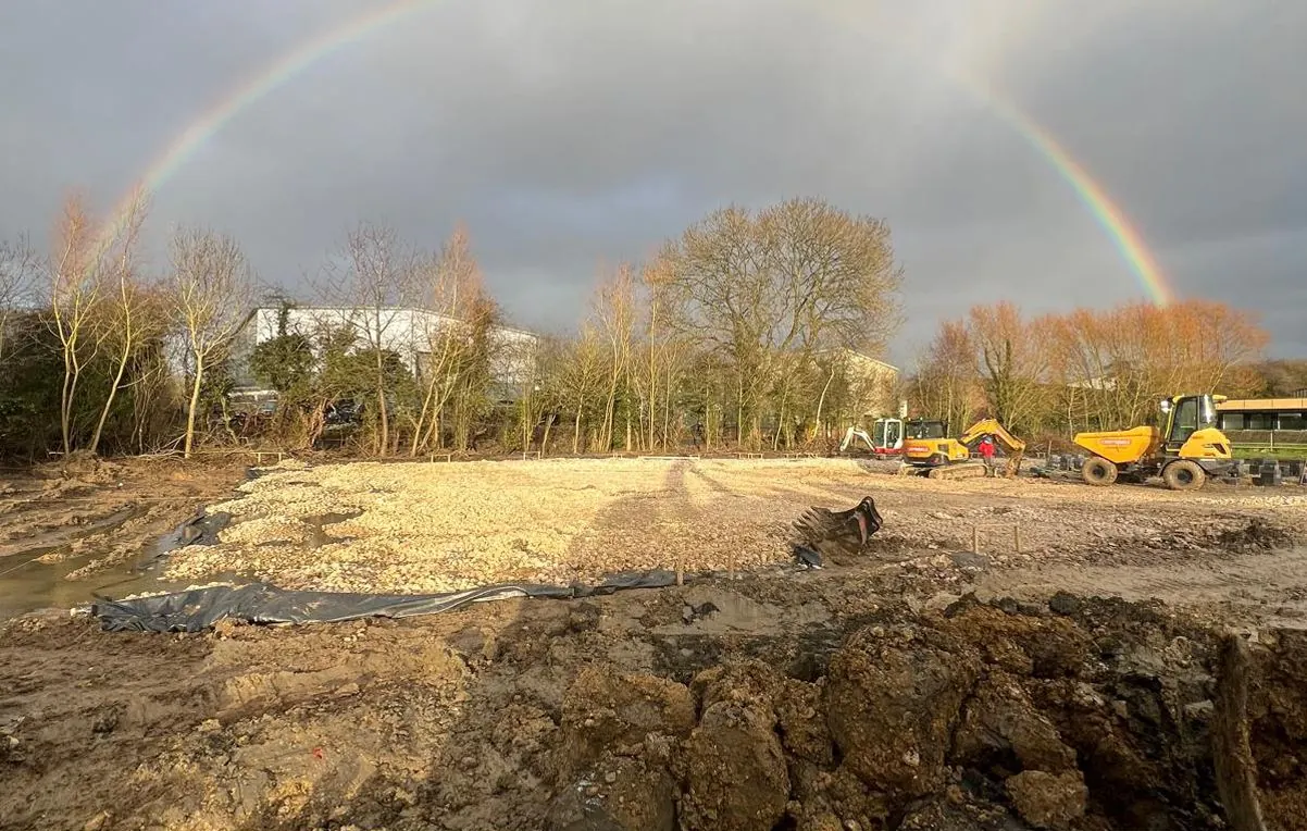 Groundworks under way on the empty site in Pickering, with diggers, a dumper and a rainbow overhead