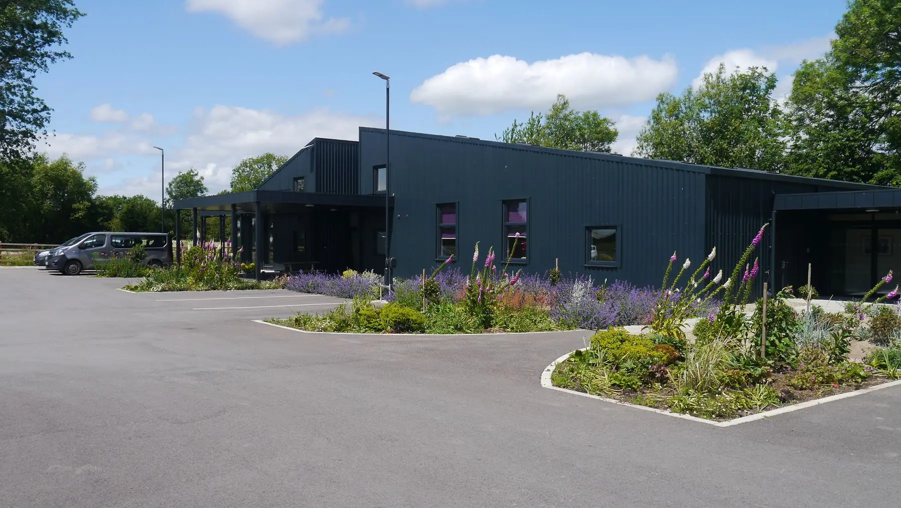 Ryedale Special Families' new headquarters in Pickering, clad in dark profiled metal with a covered entrance canopy and planted borders